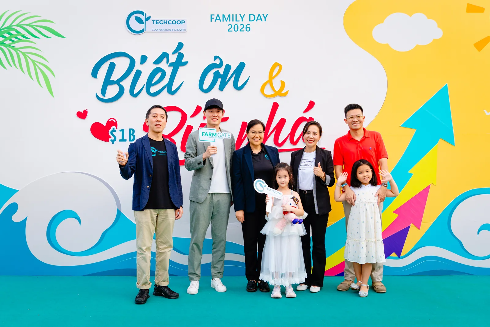 TechCoop colleagues and families posing together at a company event